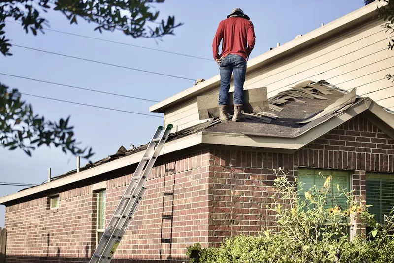 Professional roofer working on a residential roof in Home Gardens